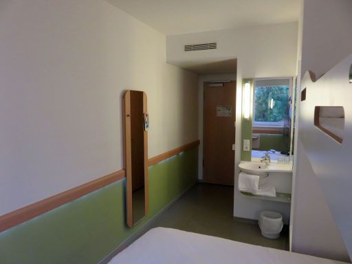 ibis budget Nuernberg City Messe, Nürnberg, Deutschland, Zimmer 21 mit Wandspiegel, Klimaanlage, Eingangstür, Waschbecken und Trennwand zur Dusche
