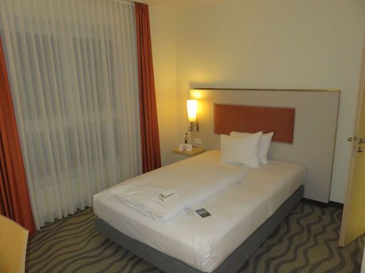 Mercure Hotel Hannover Mitte, Hannover, Deutschland, Zimmer 542 mit einem großen Einzelbett, Nachttischleuchte, Fenster und Tür zum Bad