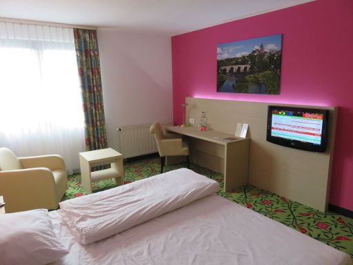 Michel Hotel Wetzlar, Wetzlar, Deutschland, Zimmer 410 mit Fenster, Vorhängen, Schreibtisch, Stuhl, Flachbildfernseher und Mineralwasser