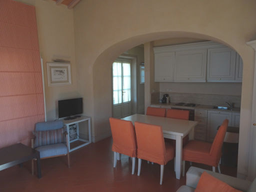 Borgo di Pratavecchie, Migliarino, Italien, Wohnzimmer mit Flachbildfernseher, Esstisch, Einbauküche und Eingangstür