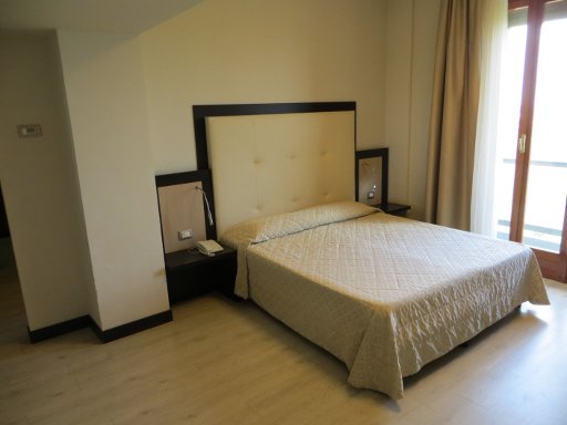 Suite Hotel Elite, Bologna, Italien, Zimmer 712 mit Doppelbett, Nachttischleuchten und Tür zum Balkon