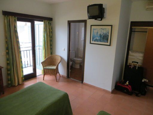 Hotel Galfi, San Antonio, Ibiza, Spanien, Zimmer 310 mit Tür zum Balkon, Sessel, Tür zum Bad und Schrank mit Minisafe