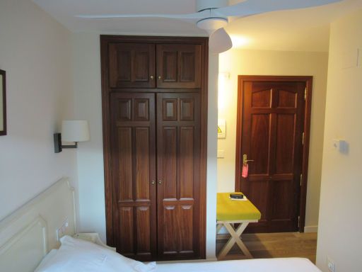 Hotel Finca Los Llanos, Capileira, Spanien, Zimmer 208 mit Wandschrank mit Minisafe, Kofferablage, Eingangtür und Flur mit Tisch und Kühlschrank