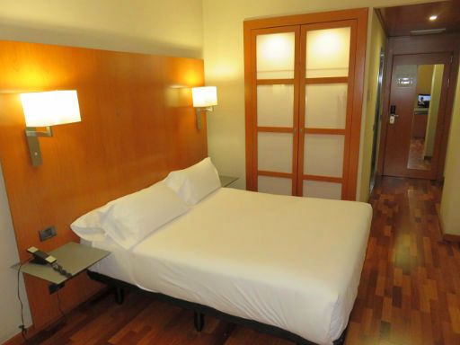 Hotel H2 Granada, Spanien, Zimmer 123 mit Doppelbett, Nachttisch, Beleuchtung, Schrank mit Beleuchtung, Klimaanlage und Eingangstür