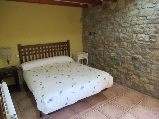 Hotel La Pradera, Quintanaentello, Spanien, Zimmer 105 mit großem Bett, Heizkörper, Nachttischleuchte und Natursteinmauerwerk