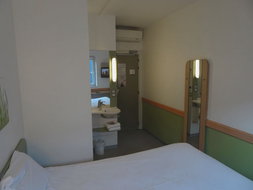 ibis budget Bilbao Barakaldo, Spanien, Zimmer 118 mit Wandspiegel, Klimaanlage und Eingangstür
