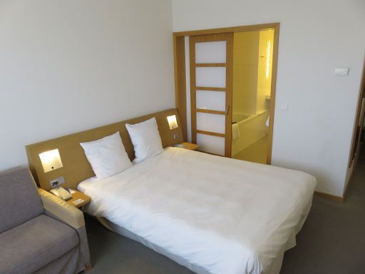 Novotel Valladolid, Spanien, Zimmer 412 mit Sofa, Doppelbett, Nachttischleuchten und Schiebetür zum Bad