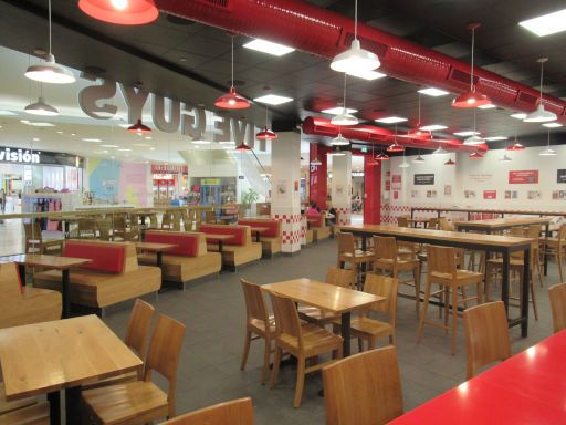 FIVE GUYS®  Burgers and fries, Madrid, Spanien, Gastraum mit Bänken, Tischen und Stühlen