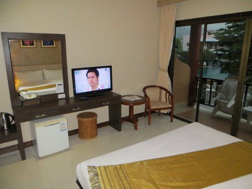 Casa Del M Resort, Patong, Phuket, Thailand, Zimmer 216 mit Wandspiegel, Kühlschrank, Flachblidfernseher, Wasserkocher, Tisch, Stuhl und Balkontür