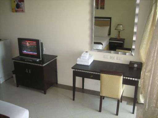 Q.D. Sweets Mansion, Pattaya, Thailand, Zimmer mit Kühlschrank, Fernseher, Wandtisch, Spiegel und Stuhl
